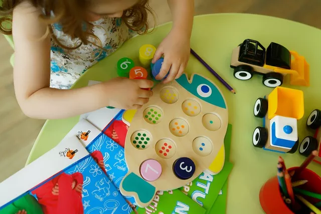 A small child playing with a colorfull puzzle, seen from above